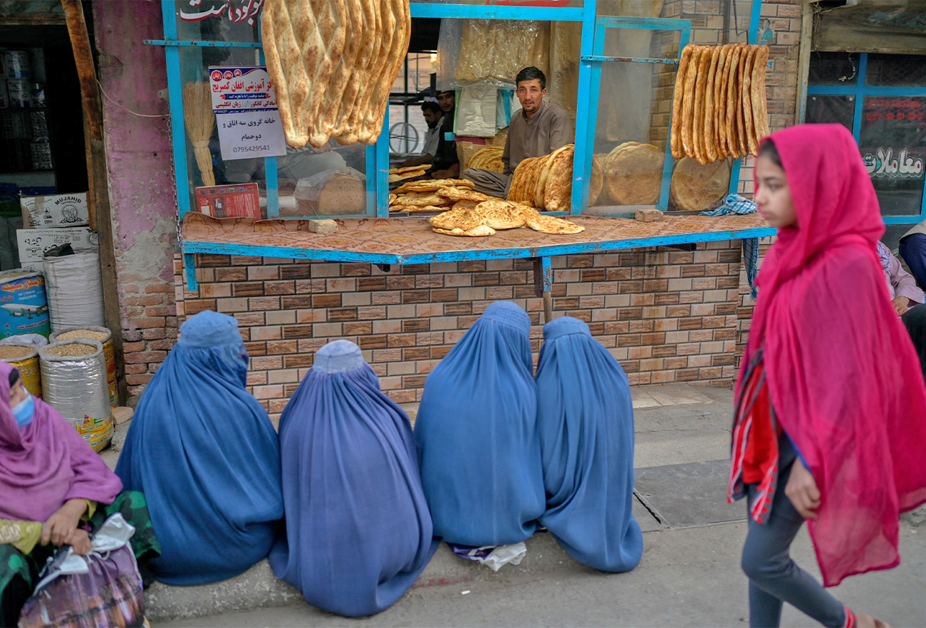 Burqa-clad women wait for free bread in front of a bakery in Kabul, Afghanistan, on September 16, 2021. (AFP)