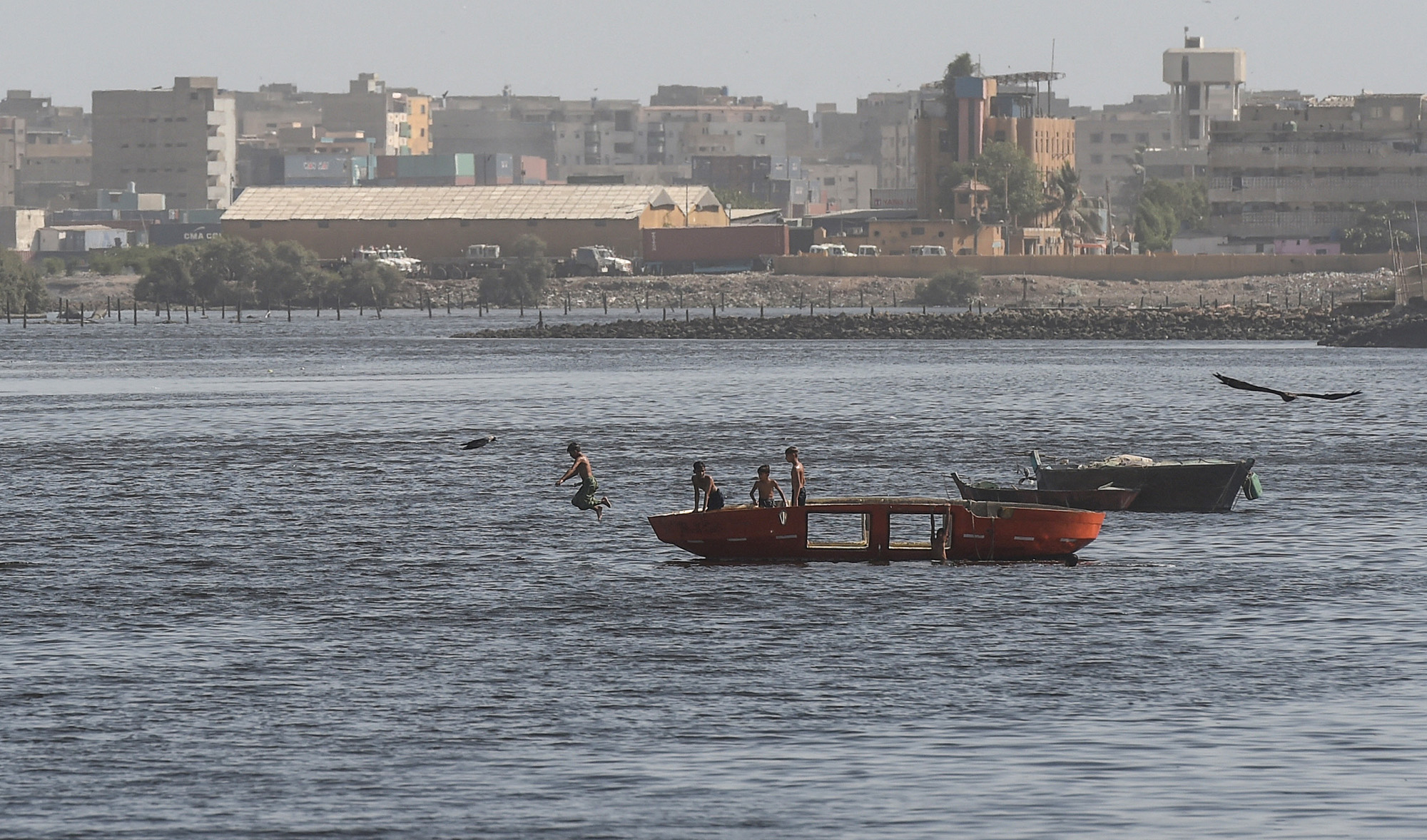 Pakistani youth enjoy swimming in Arabian Sea water after the government eased the nationwide lockdown imposed as a preventive measure against the COVID-19 coronavirus, in Karachi on May 17, 2020. (AFP/File)