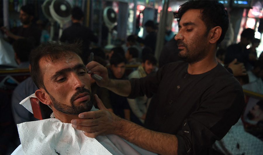An Afghan barber cuts the hair of a customer in Kabul on August 21, 2018. (AFP/ FILE)