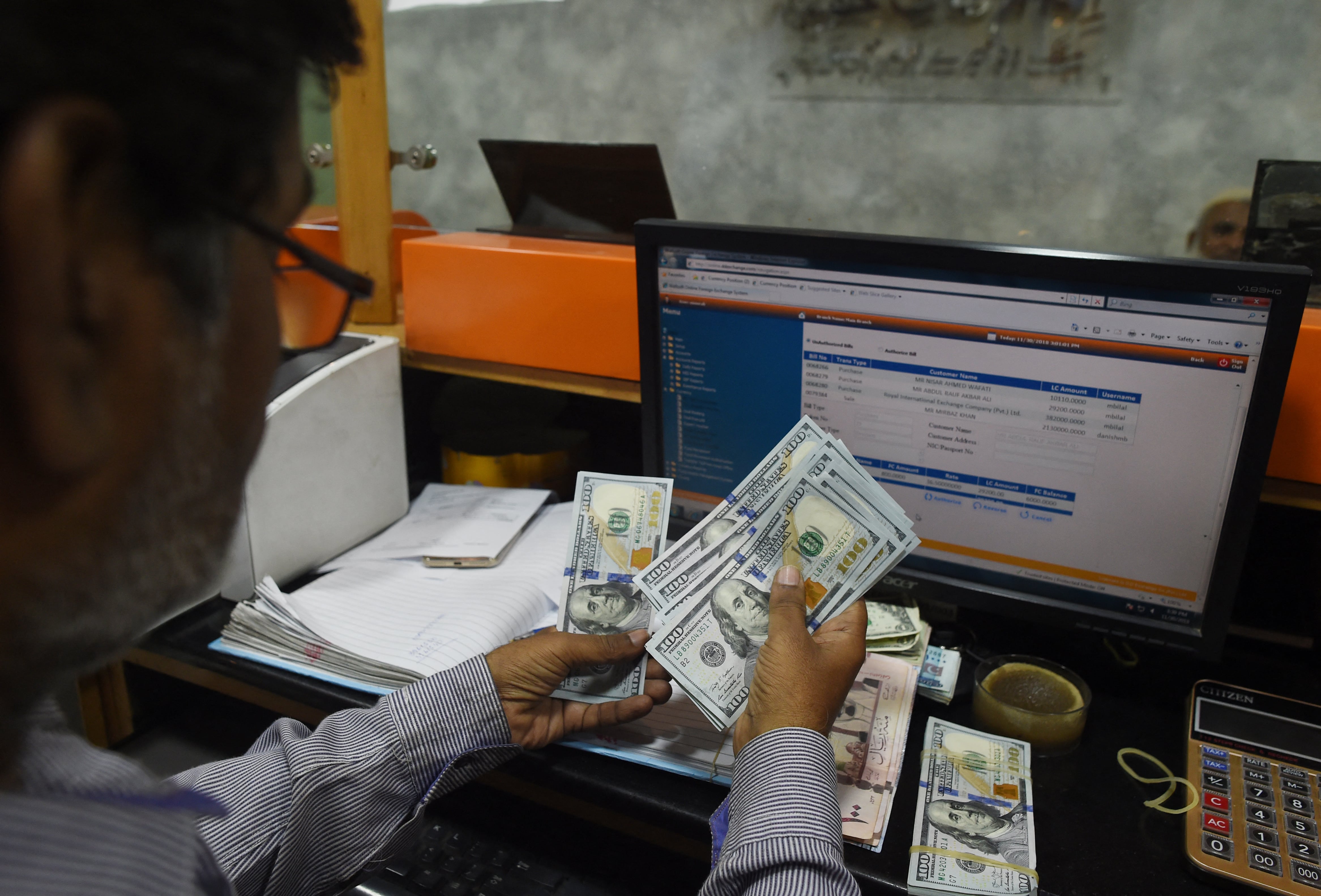 A Pakistani dealer counts US dollars at a currency exchange shop in Karachi on November 30, 2018. (AFP)