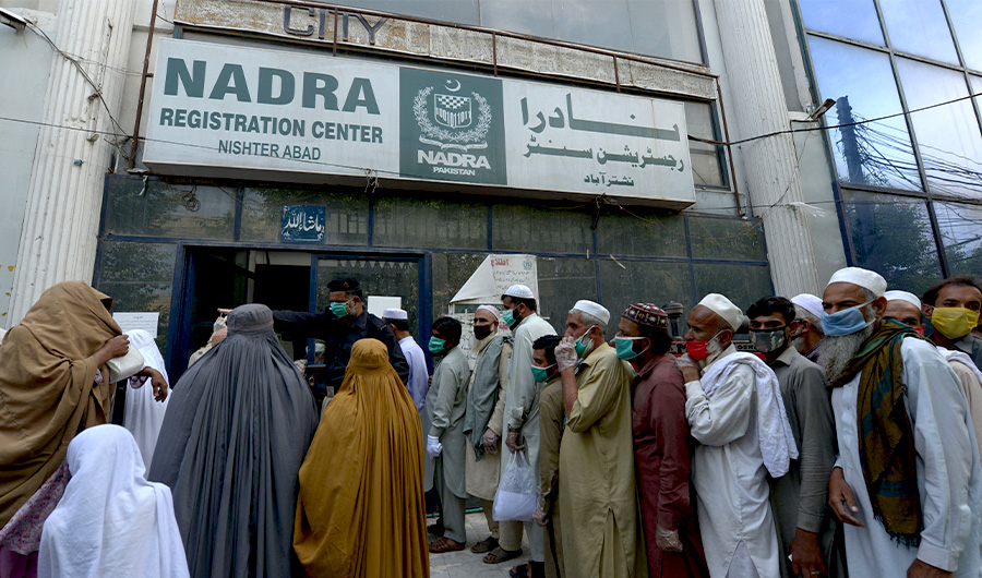 Residents wearing facemasks line up in a queue outside the National Database and Registration Authority office in Peshawar on May 4, 2020. (AFP)