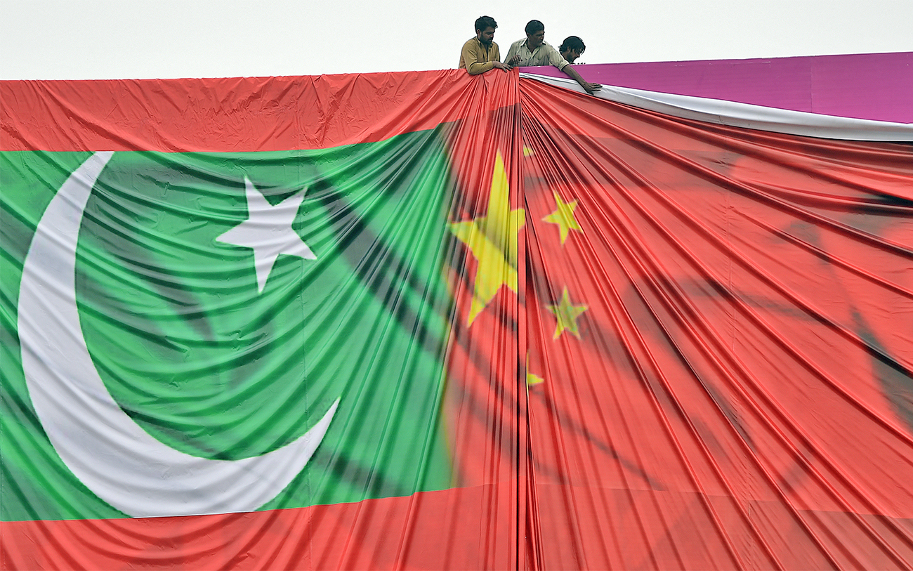 Pakistani labourers arrange a welcome billboard featuring the Chinese and Pakistani national flags ahead of the forthcoming visit by Chinese President Xi Jinping in Islamabad, Pakistan, on April 18, 2015. (AFP)