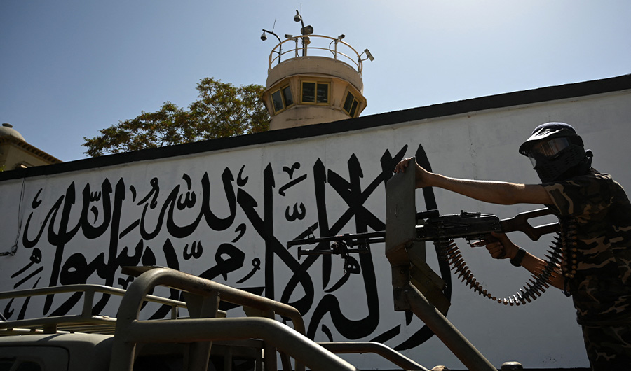 A member of the Taliban Fateh, a "special forces" unit, stands guard atop a vehicle outside the US embassy in Afghanistan displaying a Taliban flag in the outer concrete wall in Kabul on September 8, 2021. (AFP)