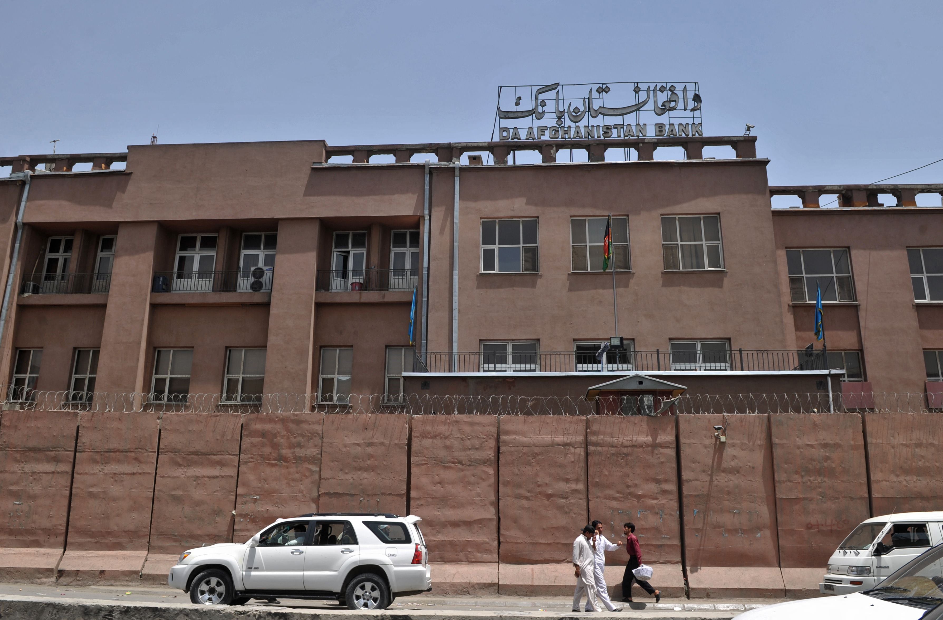 Afghan men walk past Da Afghanistan Bank in Kabul on June 28, 2011. (AFP/ File)