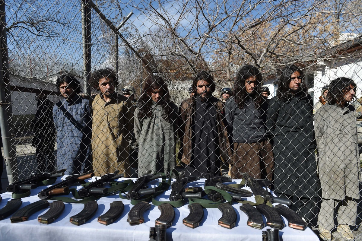 Pakistani Taliban fighters stand with their seized weapons as they are presented to the media in Kabul on January 5, 2016. (AFP/ File)
