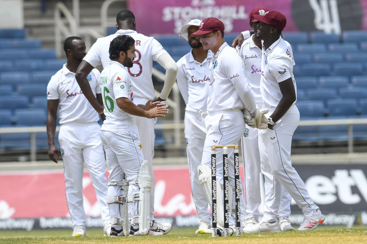 Mohammad Rizwan (L) of Pakistan and Joshua de Silva (2R) of West Indies chat while match officials make a decision about the bowler's slippery run up area during day 3 of the 2nd Test between West Indies and Pakistan at Sabina Park, Kingston, Jamaica, on August 22, 2021. (AFP)
