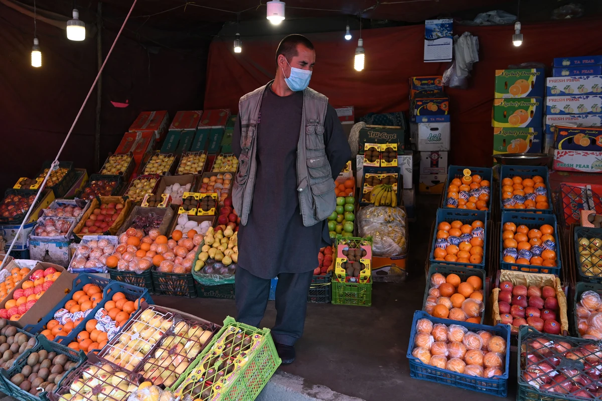 In this photo taken on April 20, 2020 a fruit vendor wearing a facemask waits for customers during a government-imposed lockdown on the capital city as a preventive measure against the COVID-19 coronavirus, at his fruit shop in Kabul. (AFP)
