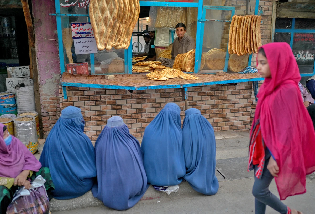 Burqa-clad women wait for free bread in front of a bakery in Kabul, Afghanistan, on September 16, 2021. (AFP)