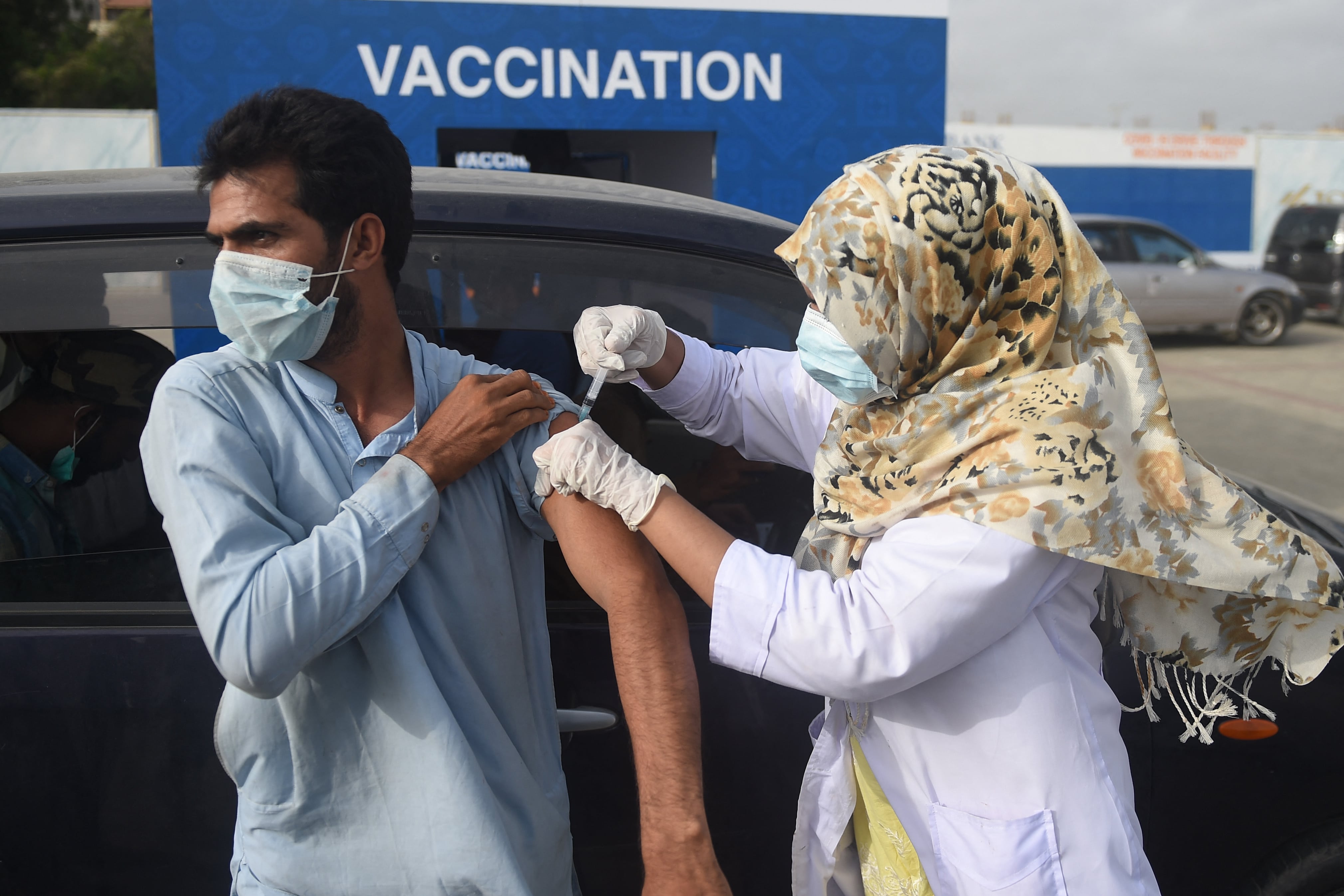 A man receives a dose of the Sinopharm vaccine against the Covid-19 coronavirus, during a drive-through vaccination in Karachi on August 3, 2021. (AFP)
