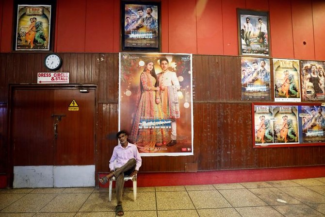 Ticket checker Mukesh, 40, sits by a wall decorated with film posters at the hall of the Bambino Cinema in Karachi, Pakistan August 30, 2018. (Reuters)