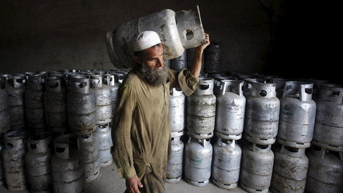 In this file photo, a worker carries a cylinder of Liquified Petroleum Gas (LPG) at a gas distribution centre in Peshawar on April 29, 2015. (REUTERS)