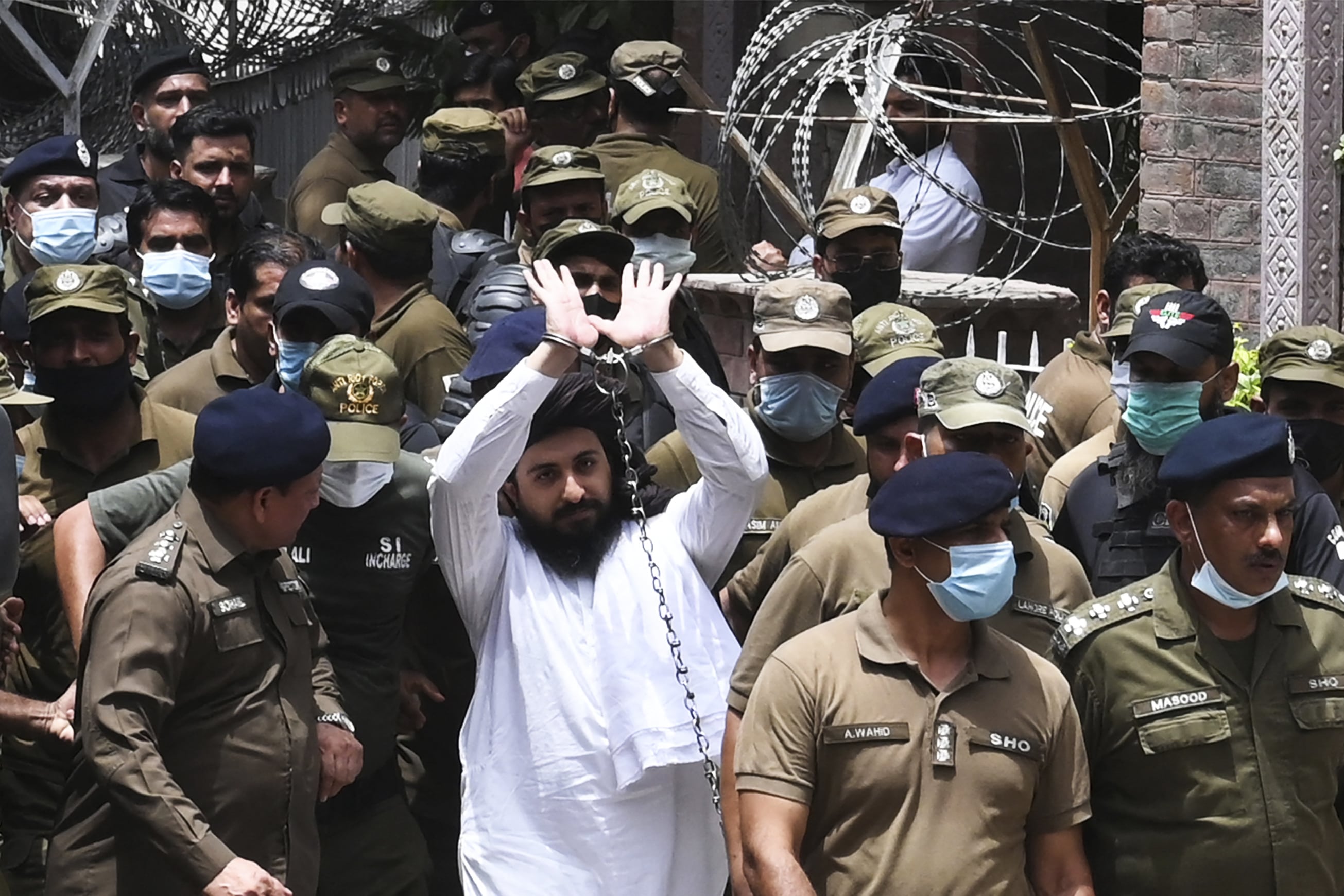 Hafiz Saad Hussain Rizvi (C), son of late Khadim Hussain Rizvi, the founder of hard line religious political party Tehreek-e-Labbaik, waves as he arrives for a case hearing outside a court in Lahore on July 2, 2021. (AFP)
