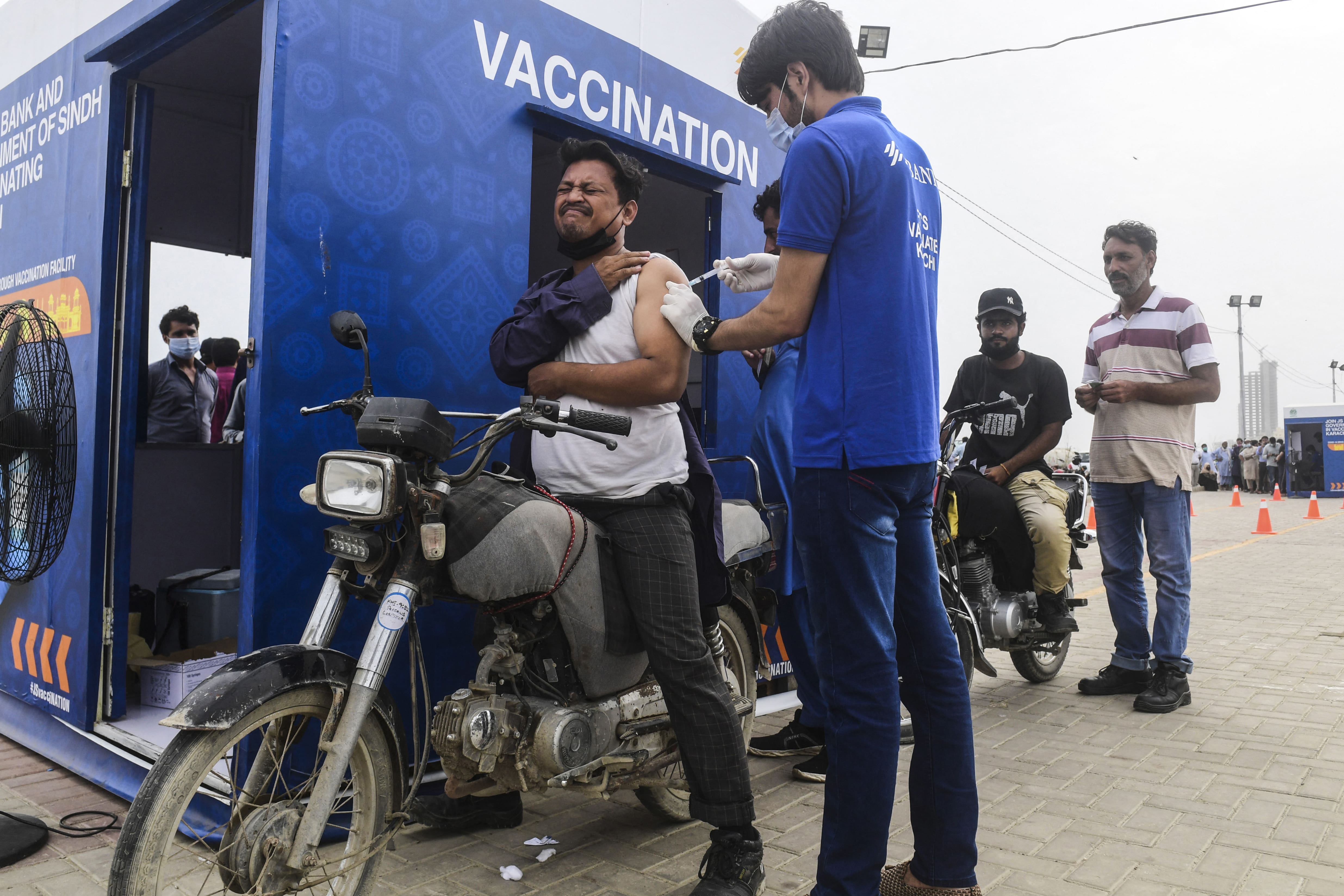 A man receives a dose of the Sinopharm vaccine against the Covid-19 coronavirus, during a drive-through vaccination in Karachi on July 26, 2021. (AFP)