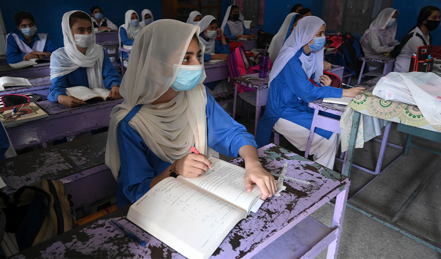 Students wearing facemasks attend a class at a school in Lahore on September 16, 2021. (AFP)