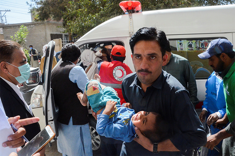 A man carries a boy who was injured, following an earthquake in Harnai, Balochistan, outside a hospital in Quetta, Pakistan, October 7, 2021. (REUTERS