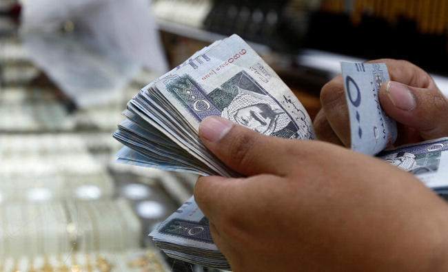 A man counts Saudi Riyal banknotes in Riyadh, Saudi Arabia, in this October 18, 2017 photo. (Reuters)