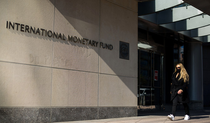 A woman walks past an International Monetary Fund headquarters(IMF) building in Washington, DC on April 5, 2021. (AFP)