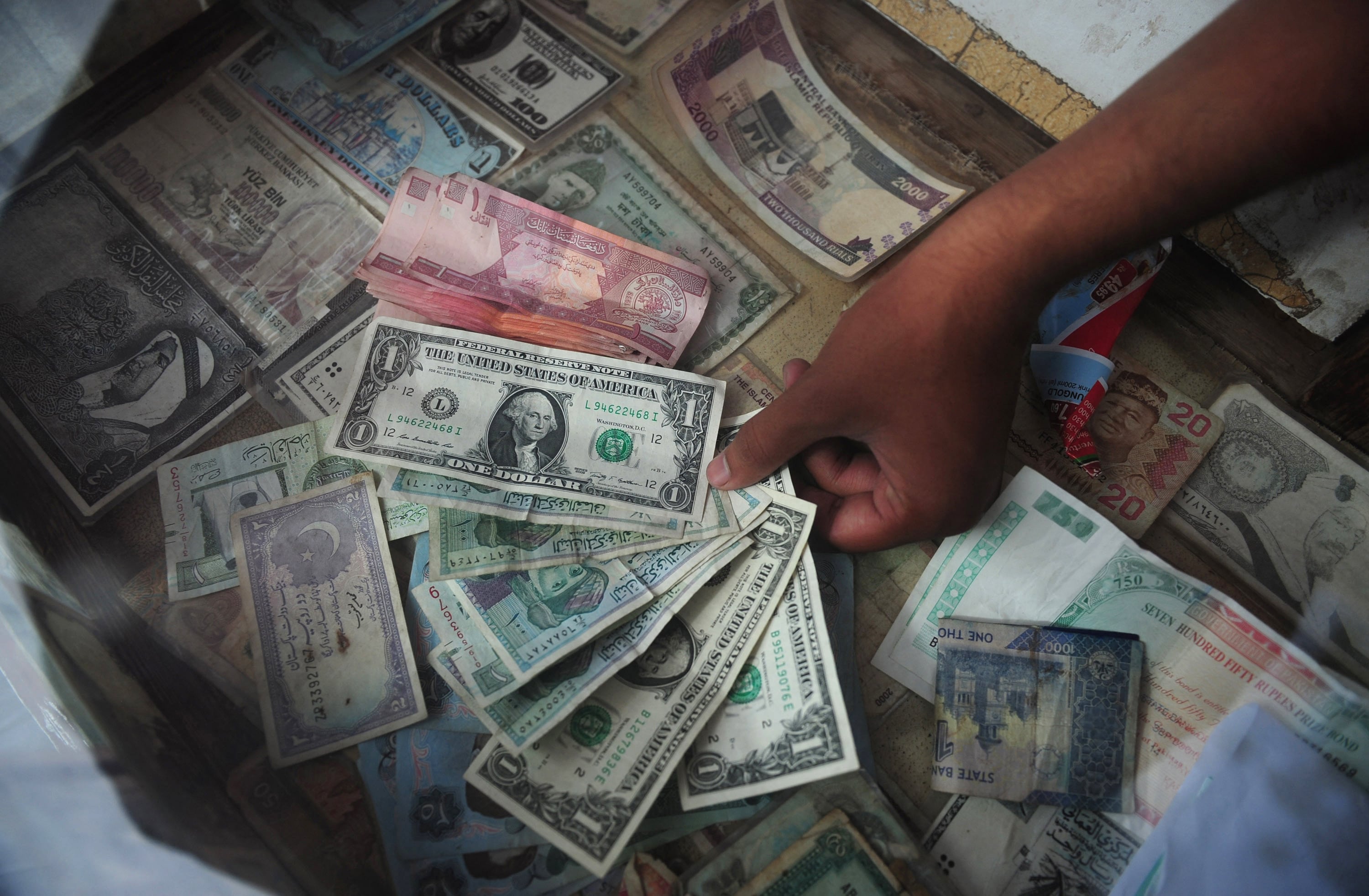 A Pakistani money exchange dealer displays foreign currency notes at his roadside stall in Karachi on August 24, 2012. (AFP/ File)