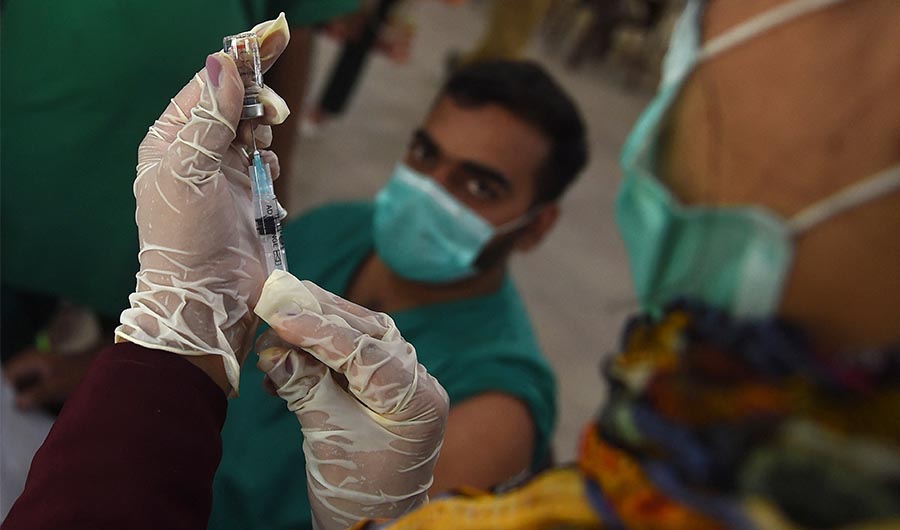 A health worker prepares to inoculate a man with a dose of the Sinopharm Covid-19 coronavirus at a vaccination centre in Karachi on May 23, 2021. (AFP)