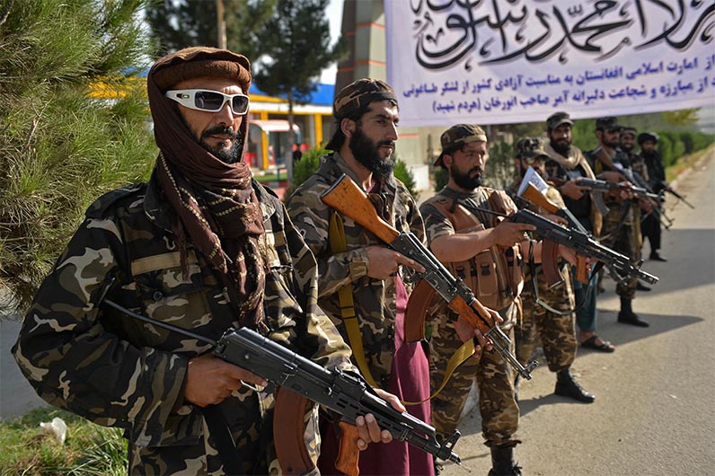 Taliban fighters stand guard near the venue of an open-air rally in a field on the outskirts of Kabul on October 3, 2021. (AFP)