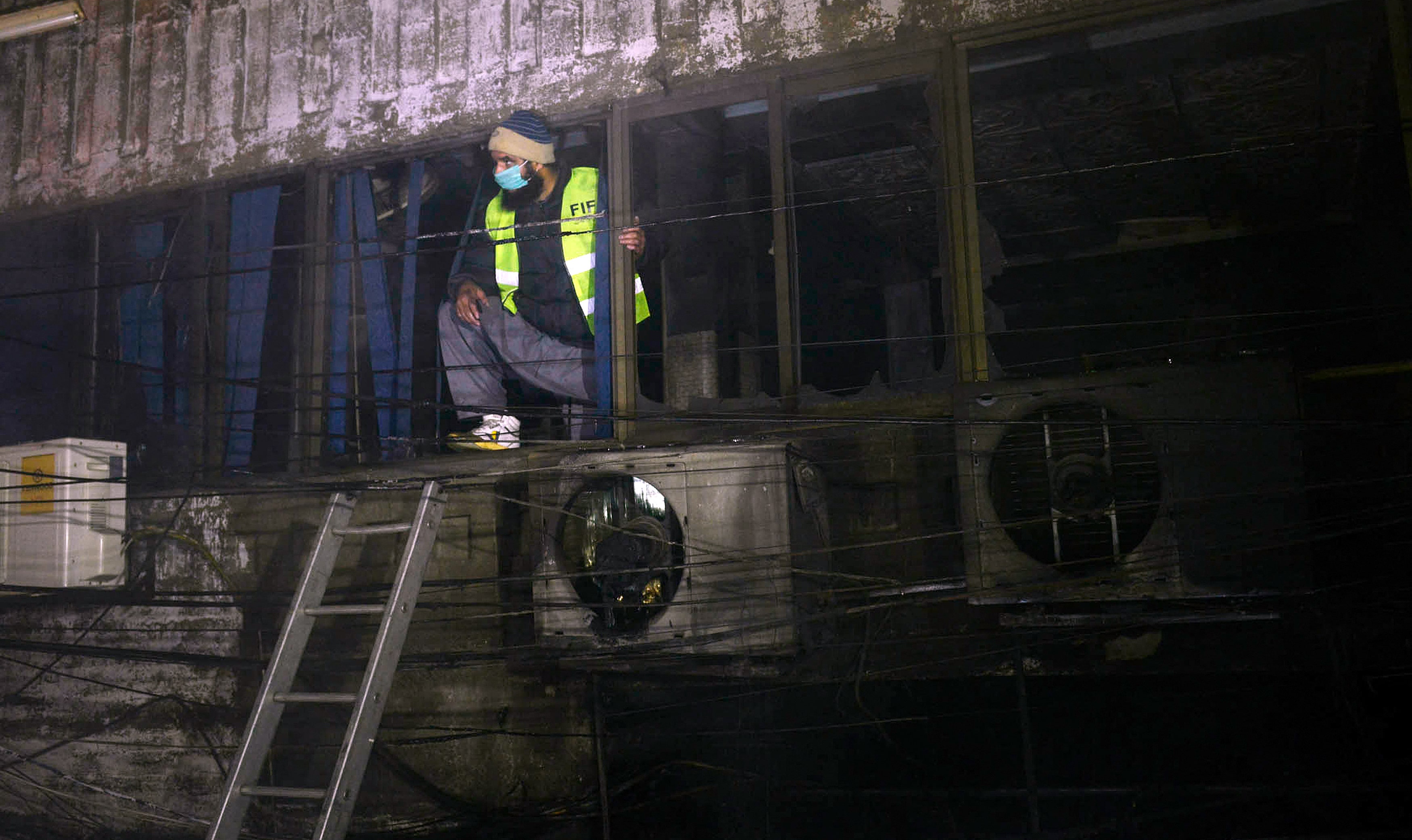 A Pakistani rescue worker looks out from a burnt out building after a fire in Lahore on December 29, 2014. (AFP/ File)