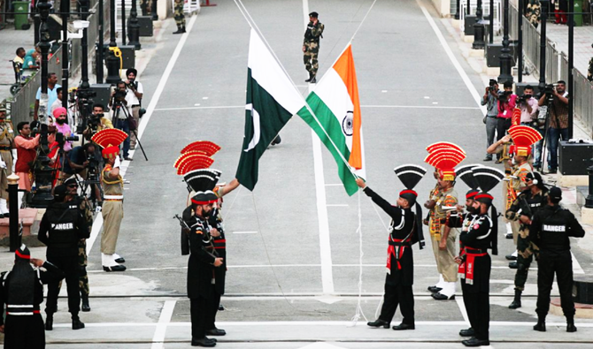 Pakistani Rangers (wearing black uniforms) and Indian Border Security Force officers lower their national flags at the Pakistan-India joint check-post at Wagah border, near Lahore, Pakistan August 14, 2018. (REUTERS/ File photo)