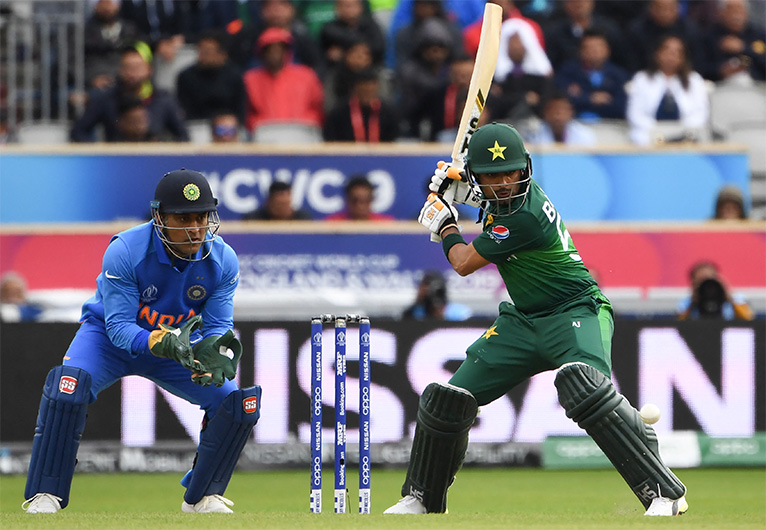 Pakistan's Babar Azam (R) is watched by India's Mahendra Singh Dhoni as he plays a shot during the 2019 Cricket World Cup match between India and Pakistan at Old Trafford in Manchester, England, on June 16, 2019. (AFP/ FILE)