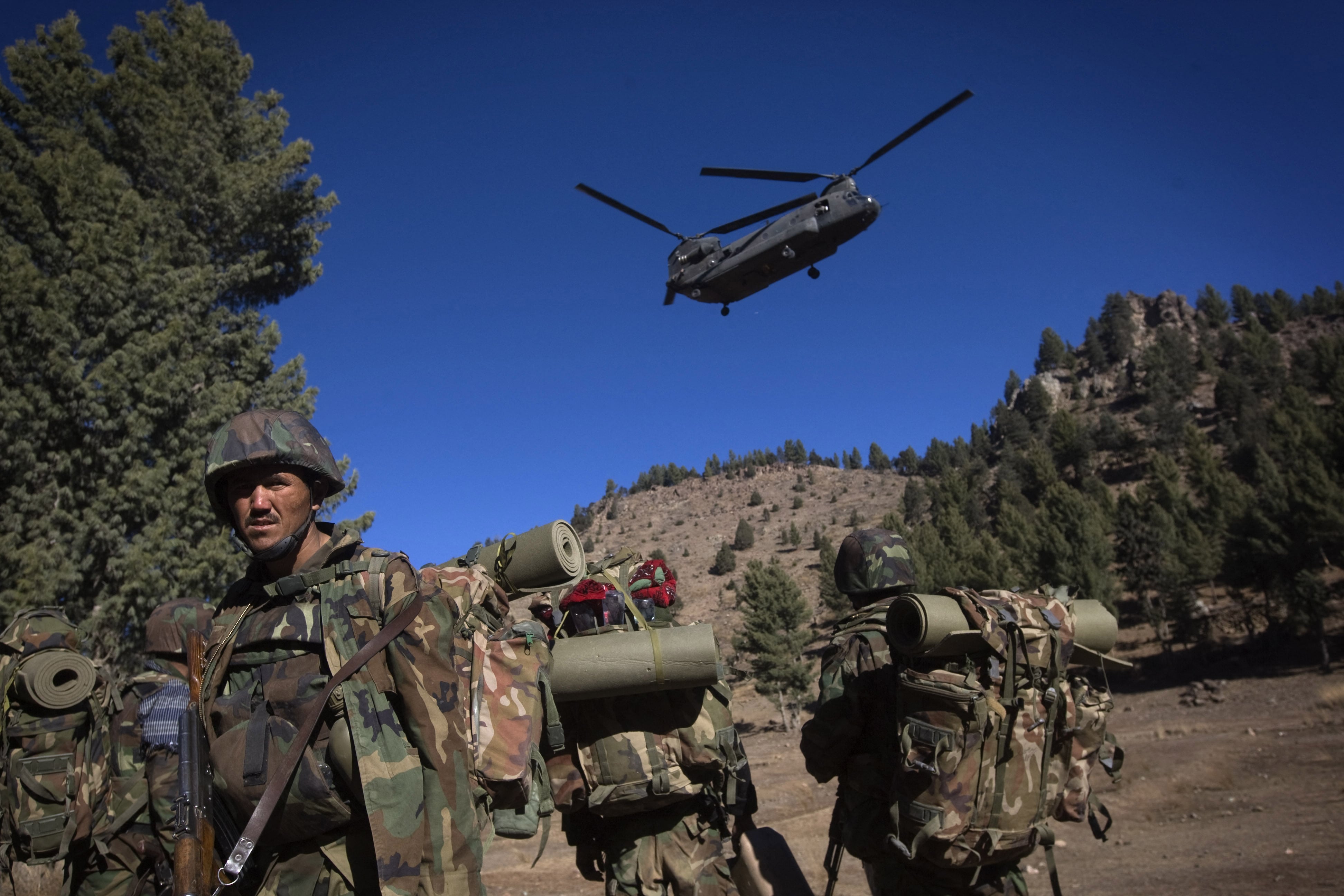 Afghan National Army soldiers take cover from dust and debris as a CH-47 Chinook helicopter lands to airlift them back to their forward operating base during day five of Operation Radu Bark VI, in the Spira mountains in Khost province, five km from the Afghan-Pakistan Border, directly across the border from Pakistan's lawless Waziristan region, on November 15, 2008. (AFP/ File)