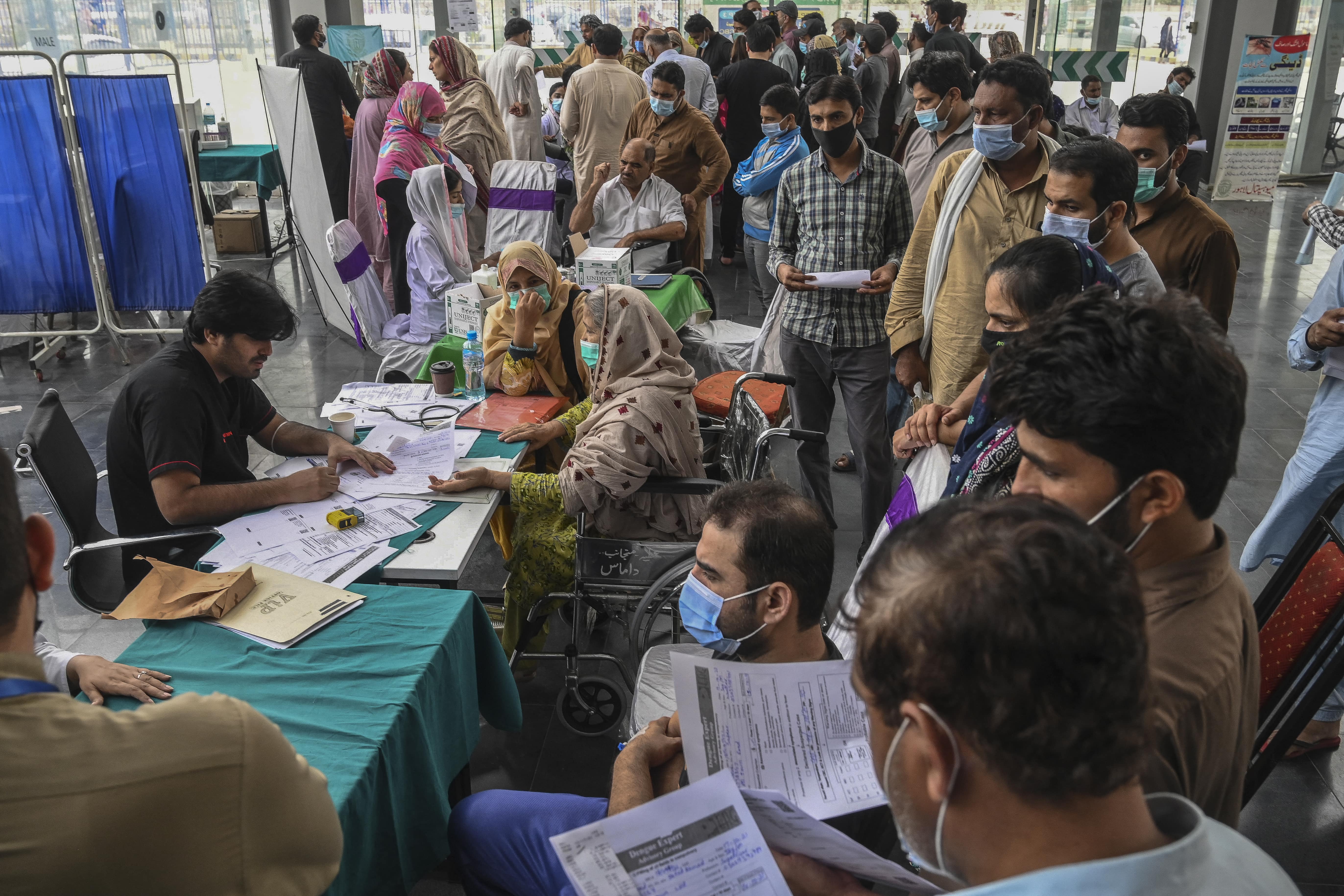 Relatives of patients infected with dengue crowd at the admission counter for bed allocation at a dengue ward in a hospital in Lahore on October 17, 2021. (AFP)