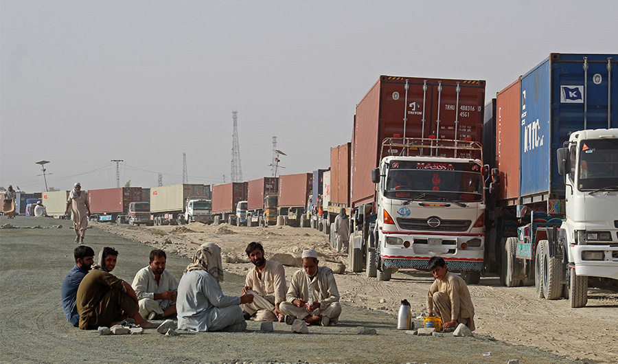 Drivers sit near to their container trucks as they wait to enter Afghanistan at the Pakistan's border town of Chaman on August 30, 2021. (AFP)