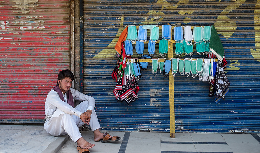 A street vendor selling facemasks sits as he waits for customers on a street in Rawalpindi on July 5, 2020. (AFP/ FILE)