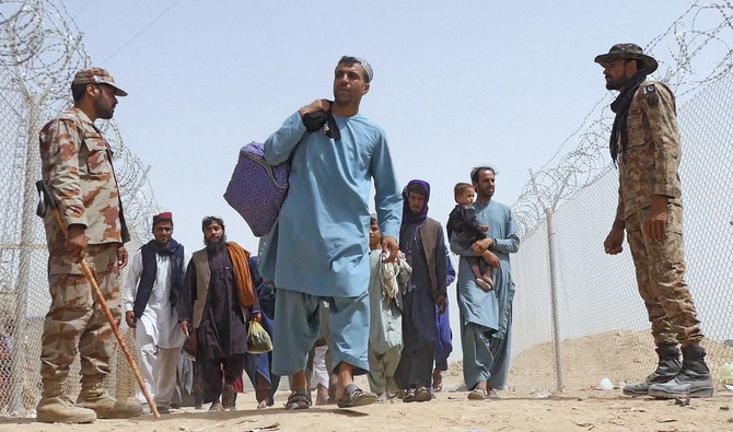 Afghans enter border town of Chaman walking past Pakistani soldiers manning the Pakistan-Afghanistan border crossing in Balochistan province - August 17, 2021. (AN photo)