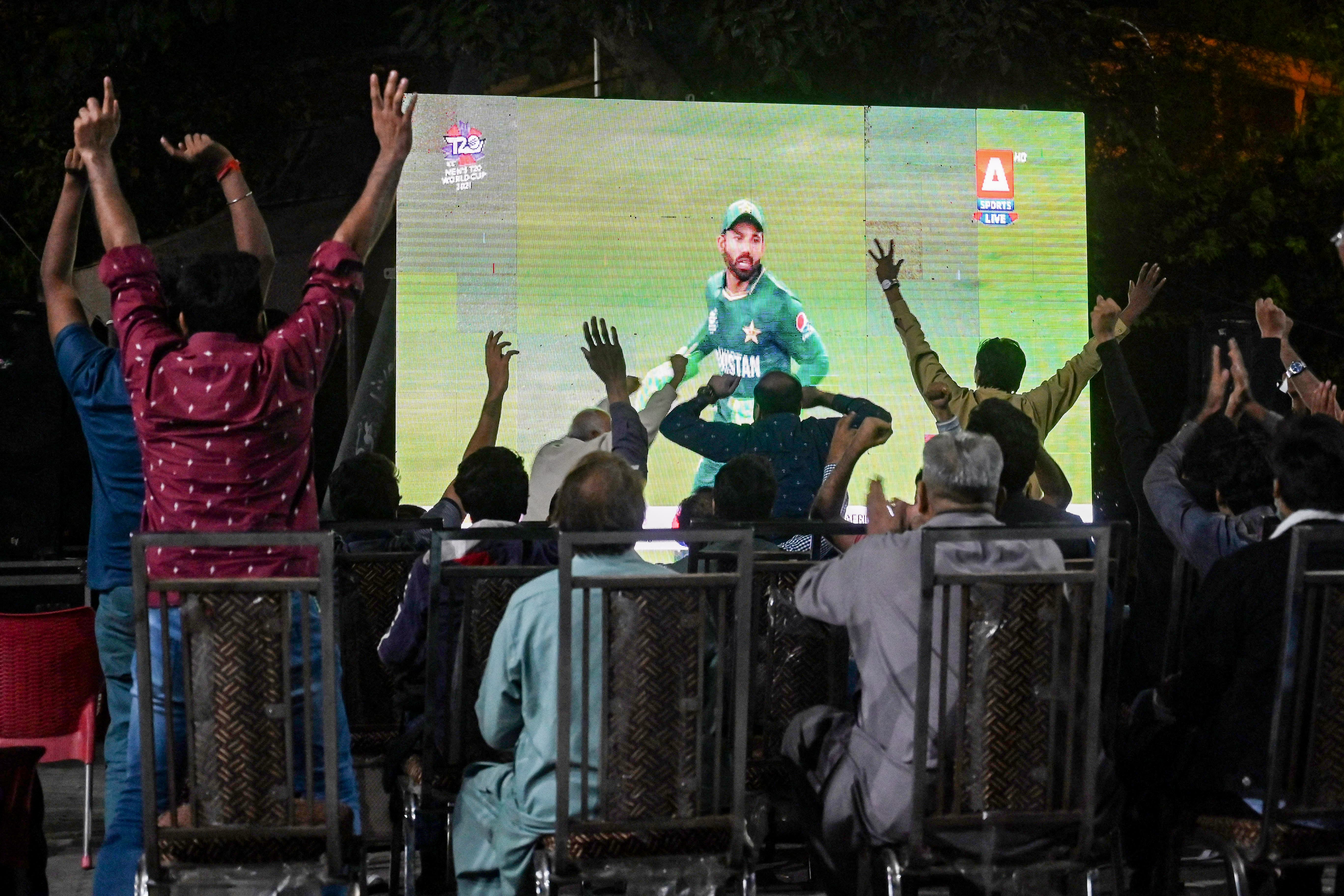 Cricket fans watch the live telecast of T20 cricket World Cup match between India and Pakistan happening in Dubai on a big screen in Lahore on October 24, 2021. (AFP)