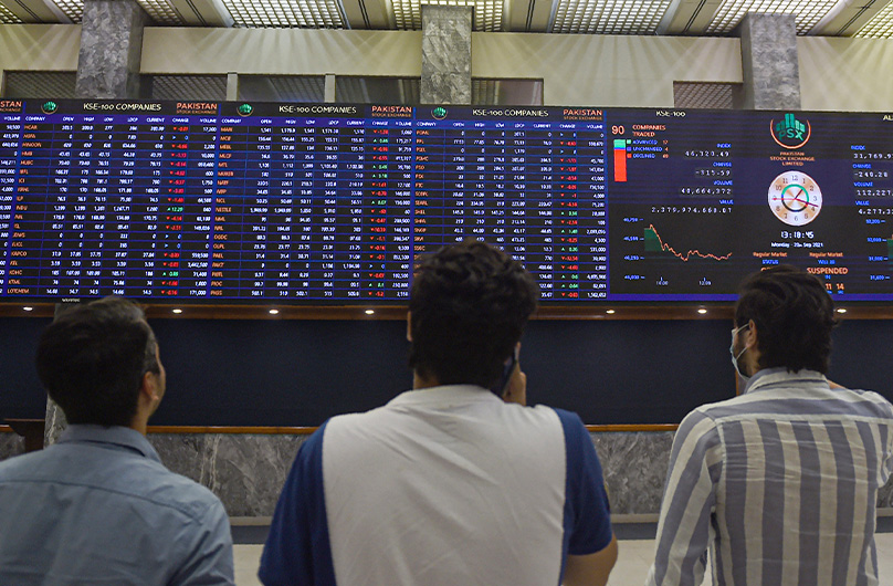 Stockbrokers watch an index board showing share prices during a trading session at the Pakistan Stock Exchange in Karachi, Pakistan, on September 20, 2021. (AFP)