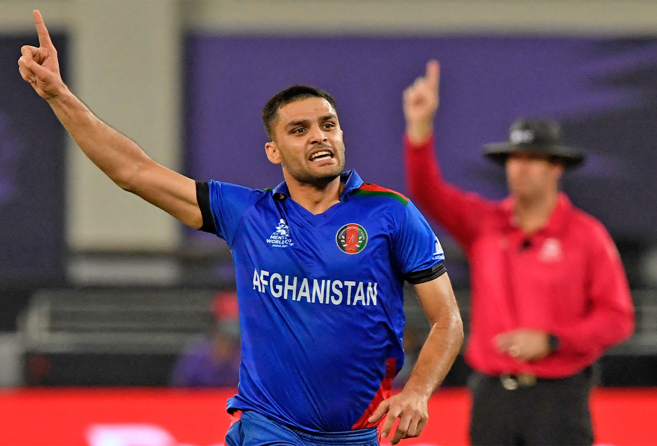 Afghanistan's Naveen-ul-Haq celebrates after taking the wicket of Pakistan's Shoaib Malik (not pictured) in T20 World Cup cricket match at the Dubai International Cricket Stadium in Dubai, UAE, on October 29, 2021. (AFP)