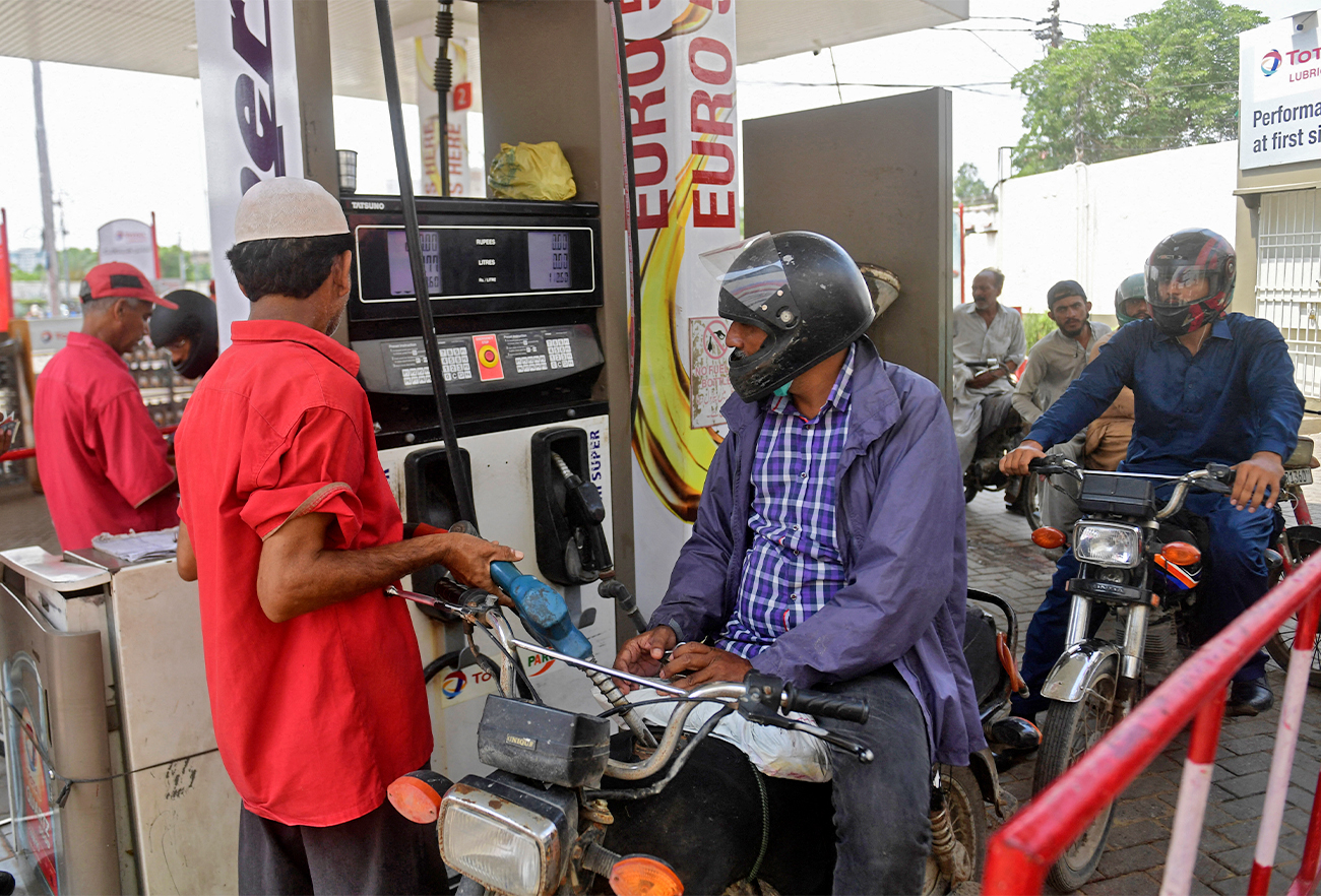 An employee of a gas station fills the tank of a motorbike in Karachi, Pakistan, on July 16, 2021. (AFP/File)