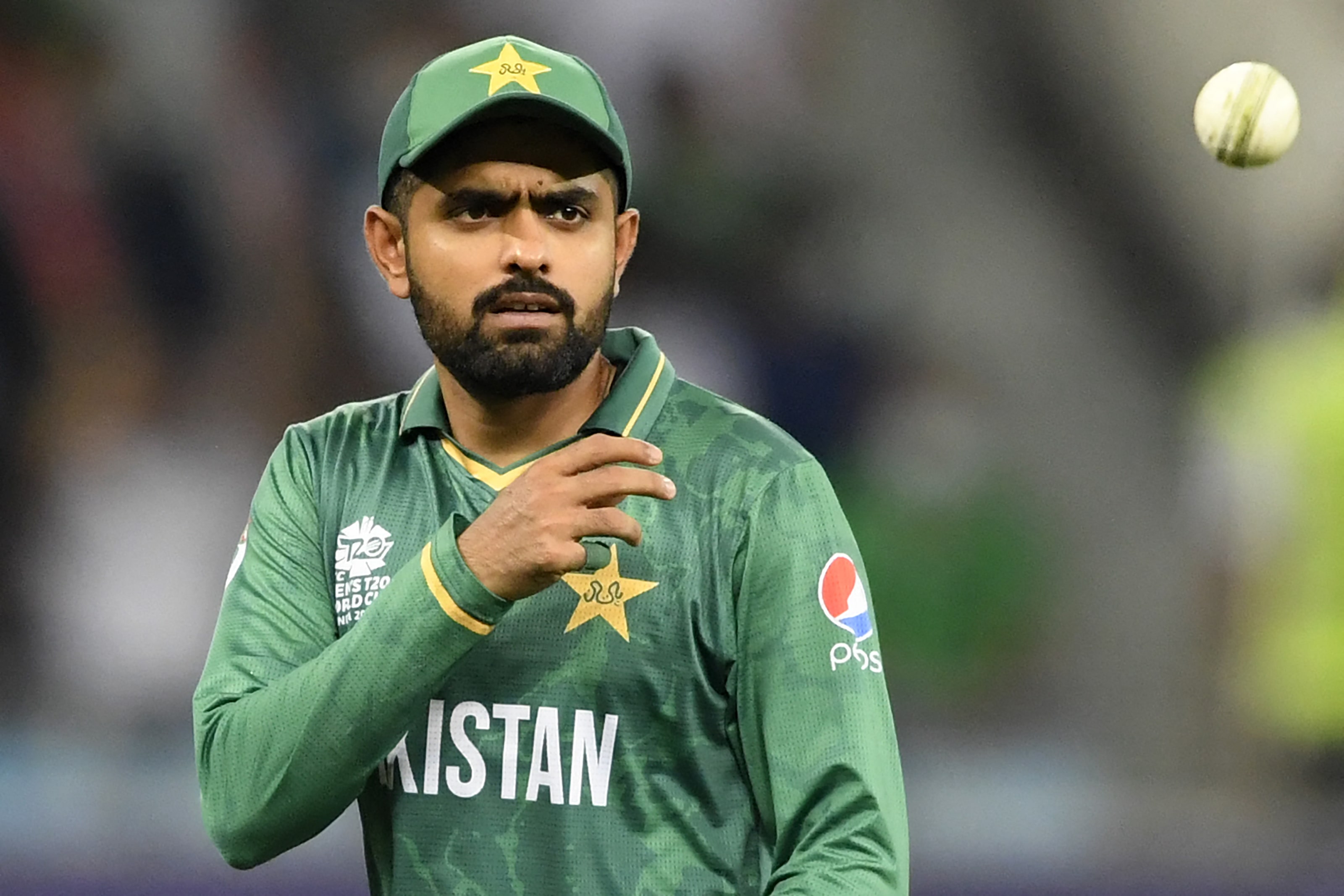 Pakistan's captain Babar Azam throws the ball during the ICC men’s Twenty20 World Cup cricket match between Afghanistan and Pakistan at the Dubai International Cricket Stadium in Dubai on October 29, 2021. (AFP)