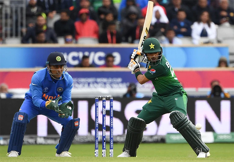 Pakistan's Babar Azam (R) is watched by India's Mahendra Singh Dhoni as he plays a shot during the 2019 Cricket World Cup match between India and Pakistan at Old Trafford in Manchester, England, on June 16, 2019. (AFP/ FILE)
