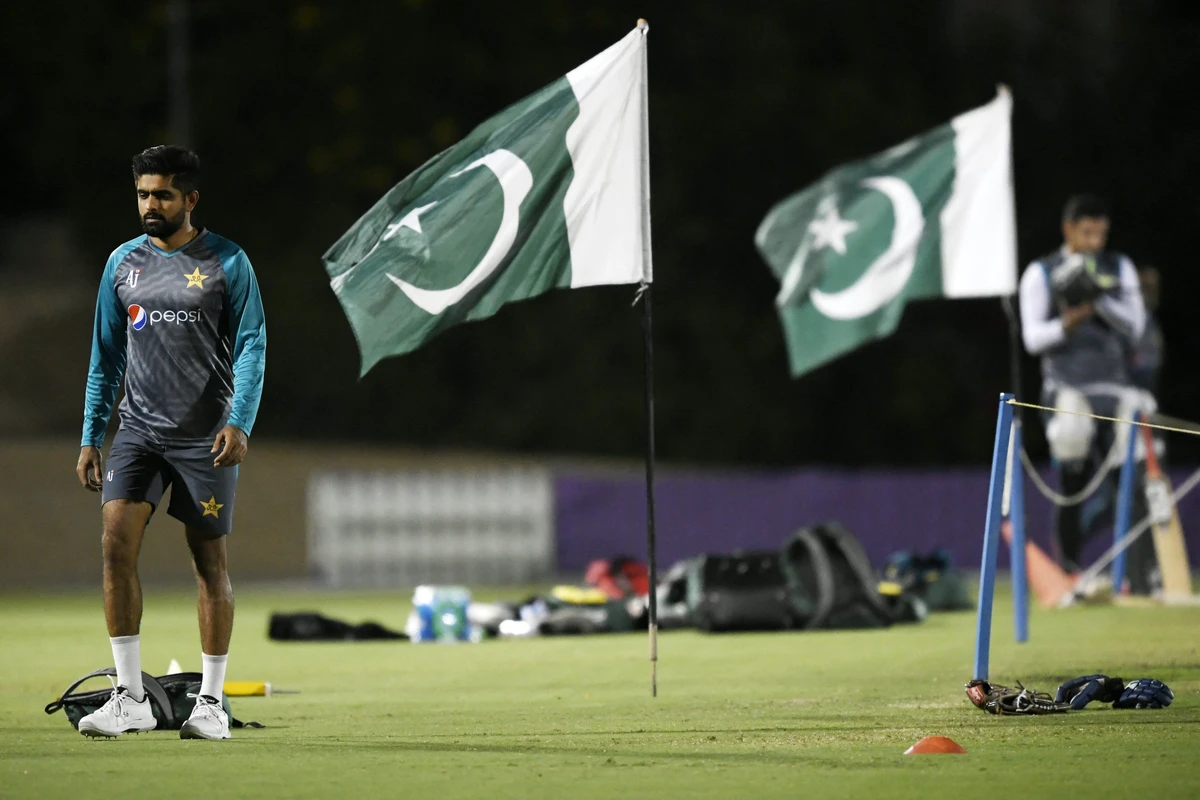 Pakistan's captain Babar Azam (L) walks past national flags during a training session at the ICC cricket academy ground in Dubai on October 19, 2021. (AFP)