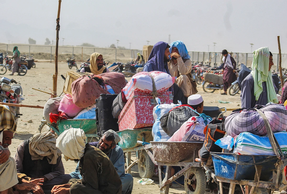 People sit with their belongings in the Pakistan side of the border after the authorities of Pakistan and Afghanistan close the movement of people across the border, in Chaman, Pakistan, on September 30, 2021. (AFP)
