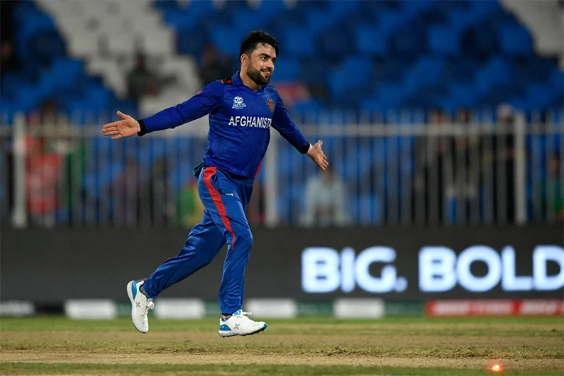 Afghanistan's Rashid Khan celebrates after taking the wicket of Scotland's Brad Wheal (not pictured) during the ICC men’s Twenty20 World Cup cricket match in Sharjah on October 25, 2021. (AFP)