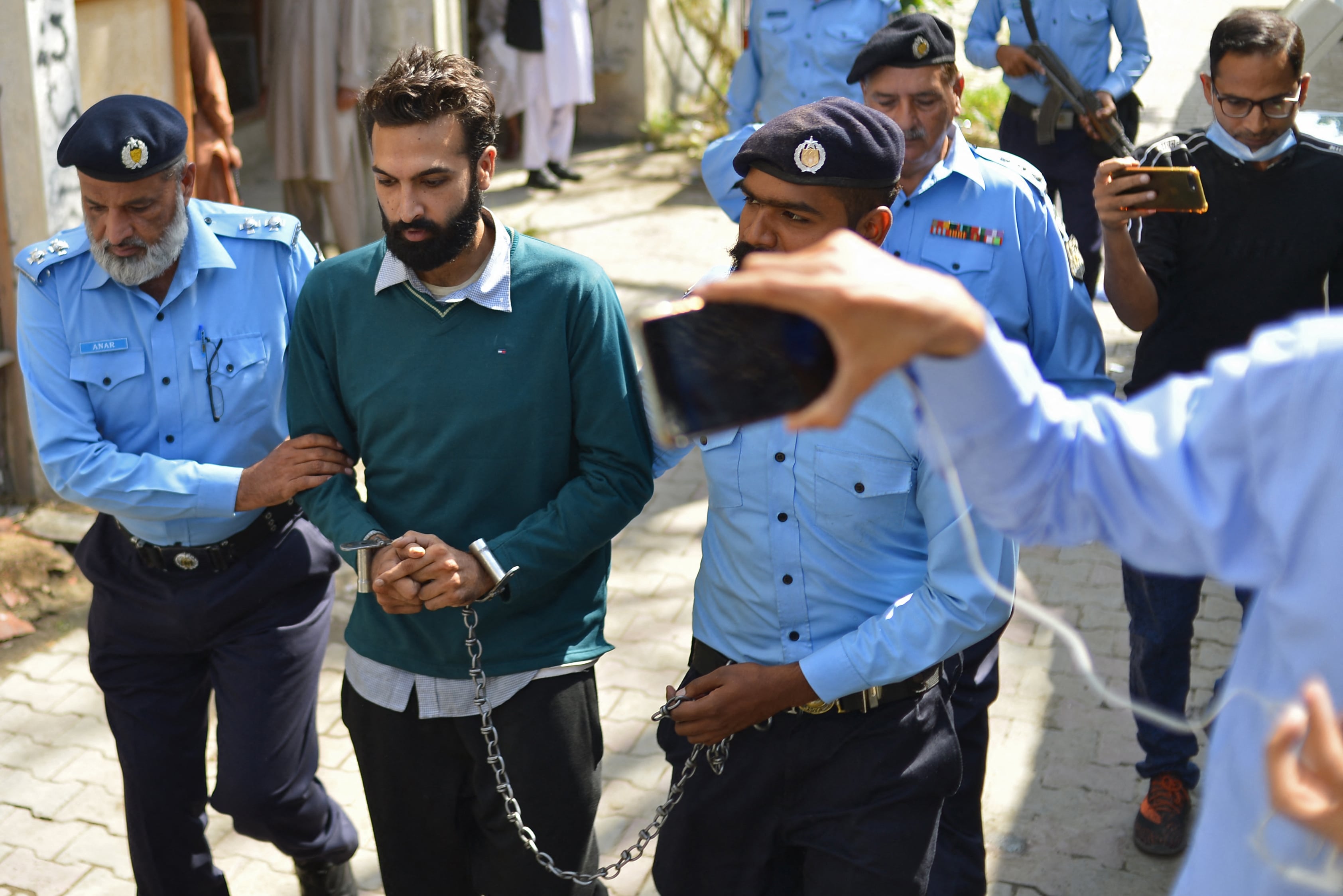 Policemen escort Zahir Jaffer (2L), a Pakistani-American man who went on trial accused of raping and beheading his girlfriend, the daughter of a former ambassador, after his court hearing in Islamabad on October 20, 2021. (AFP)