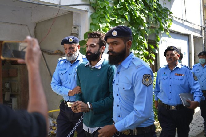 Policemen escort Zahir Jaffer, a man who went on trial accused of raping and beheading his girlfriend, after his court hearing in Islamabad, Pakistan, on October 20, 2021. (AFP)