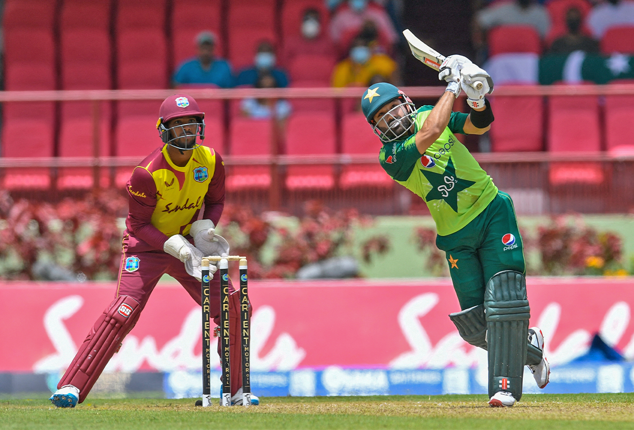 Mohammad Rizwan (R) of Pakistan hits a 6 and Nicholas Pooran (L) of the West Indies looks on during the 2nd T20I match between the West Indies and Pakistan at Guyana National Stadium in Providence, Guyana, on July 31, 2021 (AFP/File)