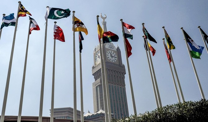 This file photo shows the national flags of the members of Organisation of Islamic Cooperation (OIC) states flying in front of the clock of the Abraj al-Bait Towers in Makkah, Saudi Arabia, on November 17, 2019. (AFP)