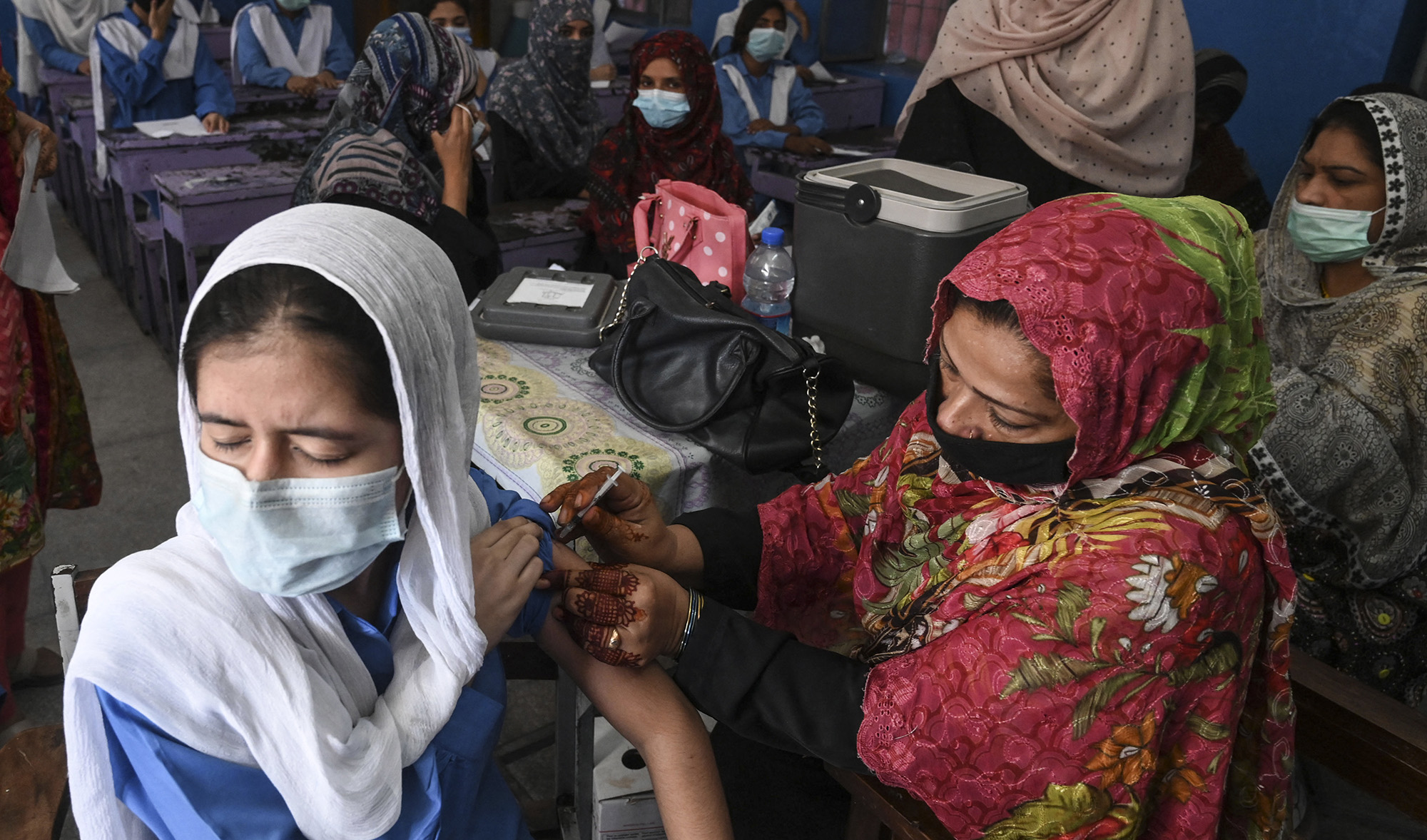 A health worker inoculates a student with a dose of Pfizer vaccine against the Covid-19 coronavirus at a school in Lahore, Pakistan on October 5, 2021. (AFP/File)