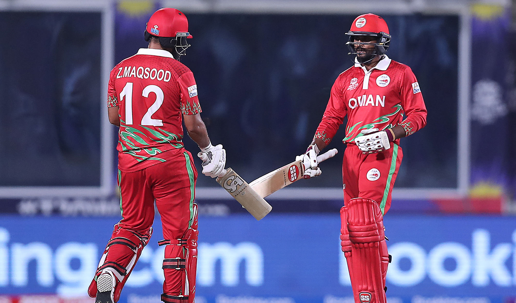 Oman's Sandeep Goud, right, and teammate captain Zeeshan Maqsood touch their bats during the ICC men's Twenty20 World Cup cricket match between Oman and Scotland at the Oman Cricket Academy Ground in Muscat on October 21, 2021. (AFP/File)