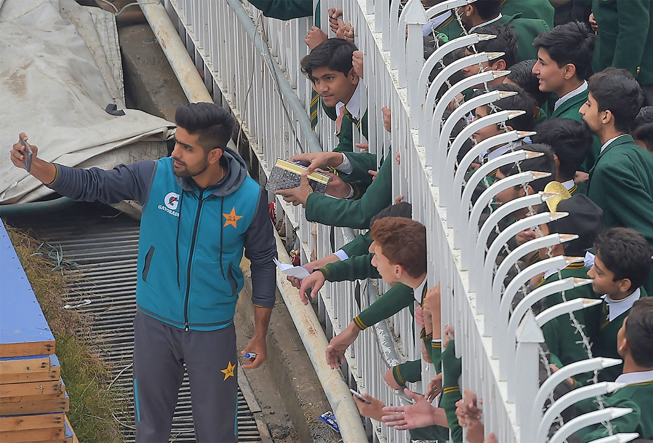 Pakistan's cricketer Babar Azam (L) takes a selfie with fans on the third day of the first Test cricket match against Sri Lanka at the Rawalpindi Cricket Stadium in Rawalpindi, Pakistan, on December 13, 2019. (AFP/File)