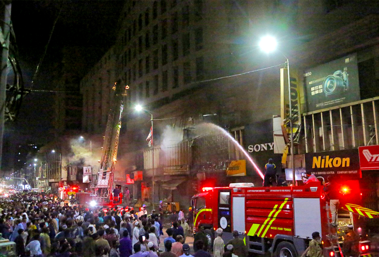 Firefighters are trying to douse a fire at the Cooperative Market in Karachi, Pakistan, on November 14, 2021. (AN Photo/S.A.Babar)
