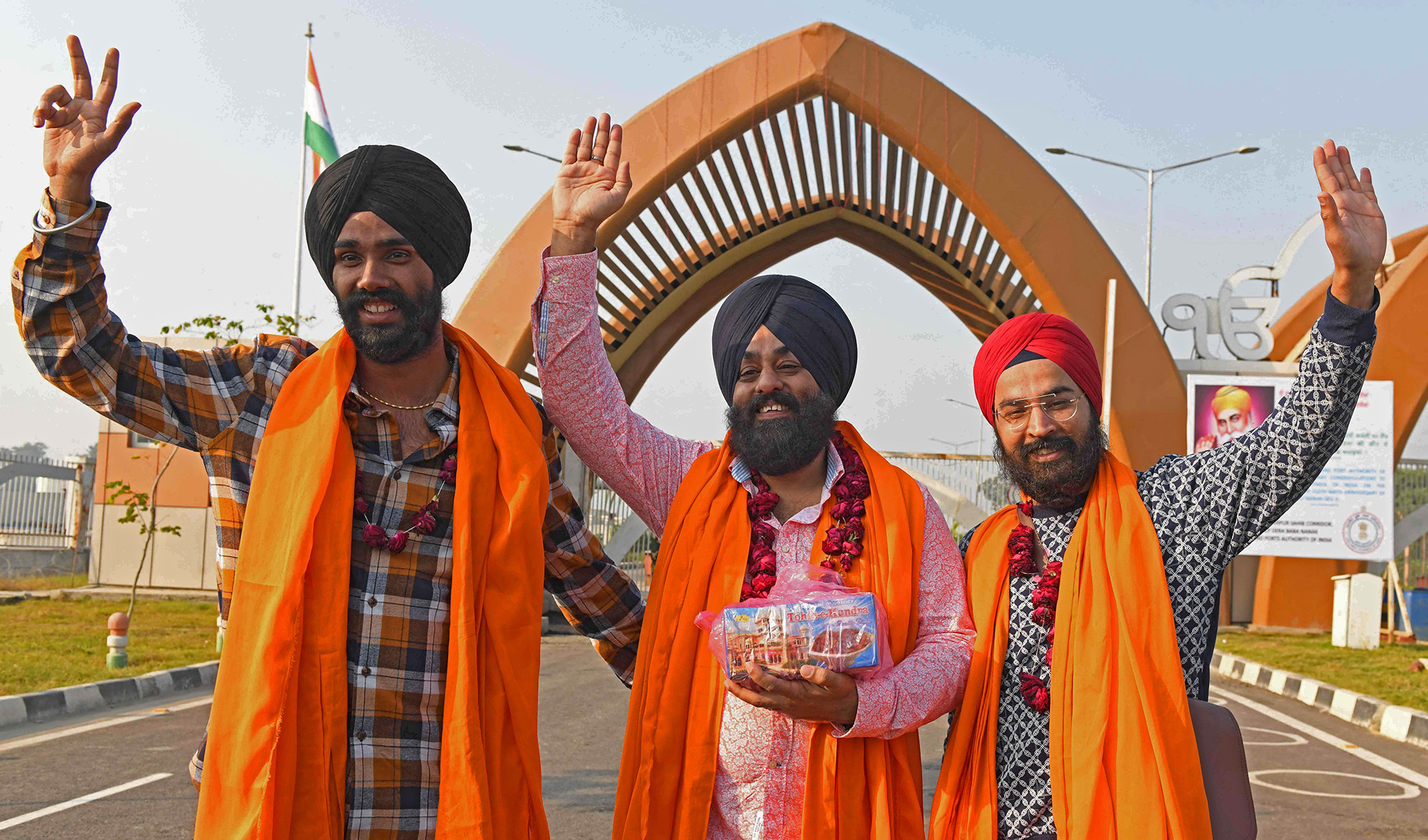 Sikh pilgrims gesture as they return from the Gurdwara Darbar Kartarpur Sahib in Pakistan after paying their respect on the occasion of Sikhism founder Guru Nanak's birth anniversary at the Kartarpur Sahib corridor on November 17, 2021. (AFP)